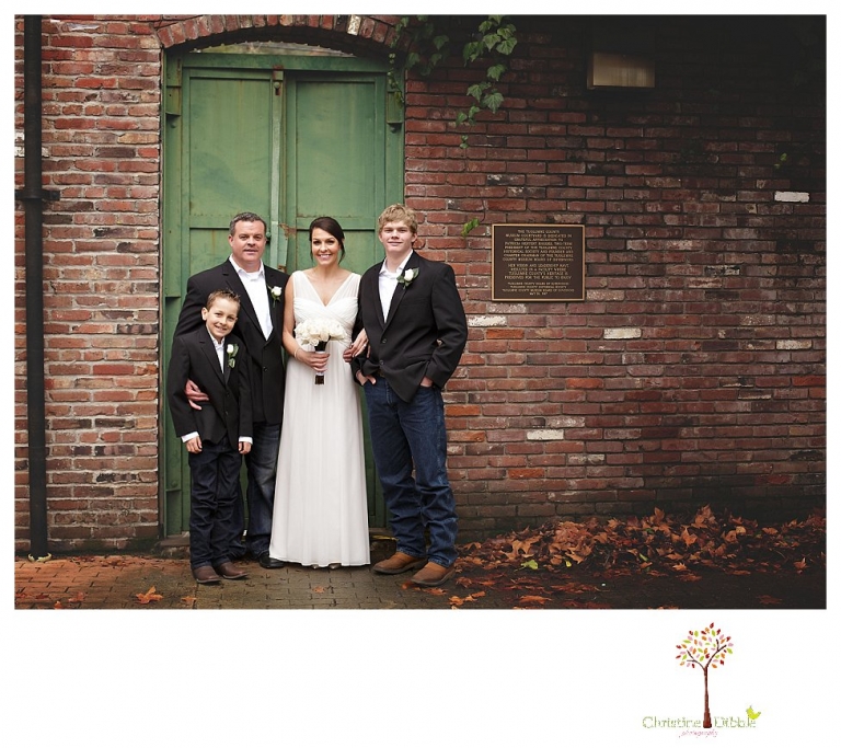 Sonora Wedding Photographer Christine Dibble Photography takes wedding portraits at an outdoor winter rainy wedding at the Tuolumne County Museum courtyard and Emberz restaurant.