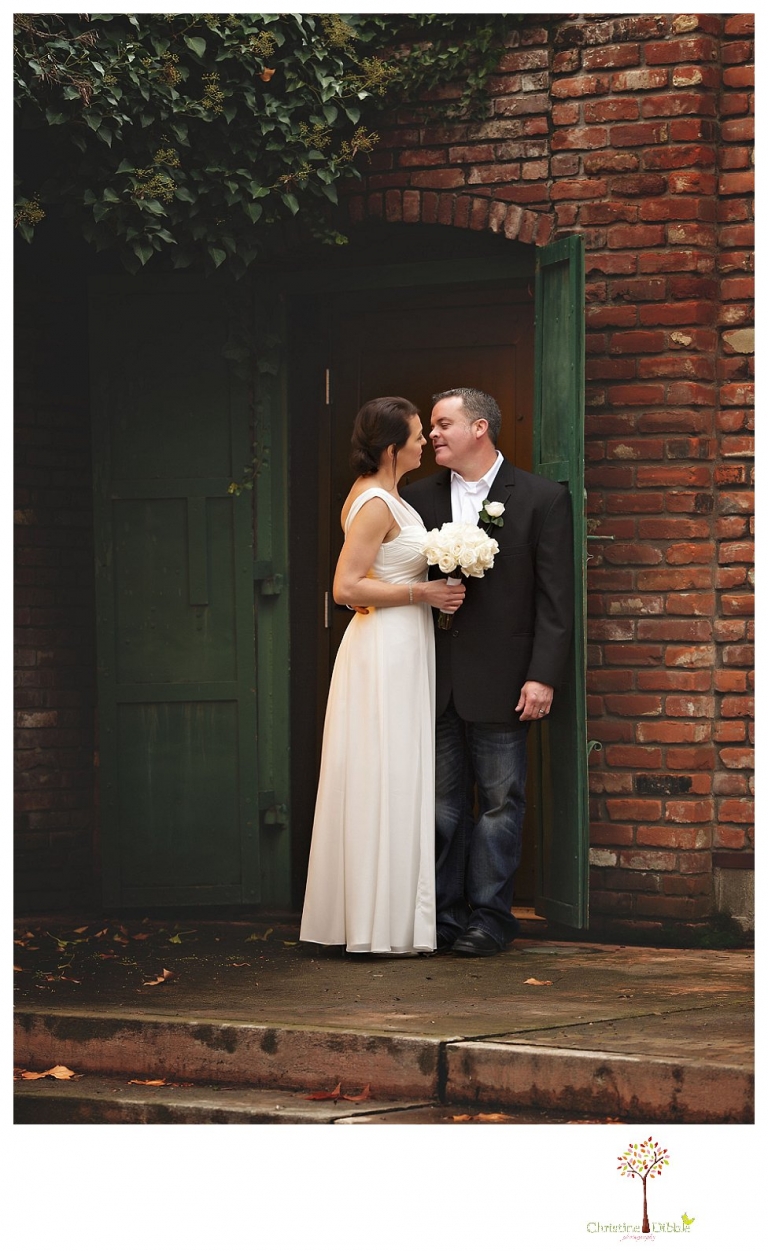 Sonora Wedding Photographer Christine Dibble Photography takes wedding portraits at an outdoor winter rainy wedding at the Tuolumne County Museum courtyard and Emberz restaurant.