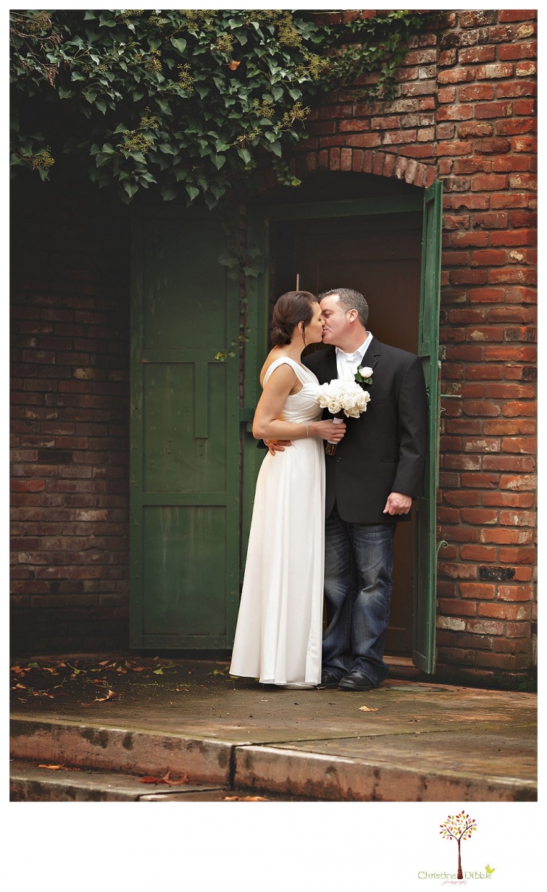 Sonora Wedding Photographer Christine Dibble Photography takes wedding portraits at an outdoor winter rainy wedding at the Tuolumne County Museum courtyard and Emberz restaurant.