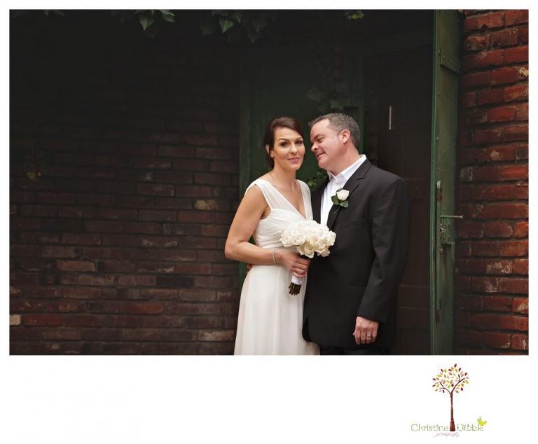 Sonora Wedding Photographer Christine Dibble Photography takes wedding portraits at an outdoor winter rainy wedding at the Tuolumne County Museum courtyard and Emberz restaurant.