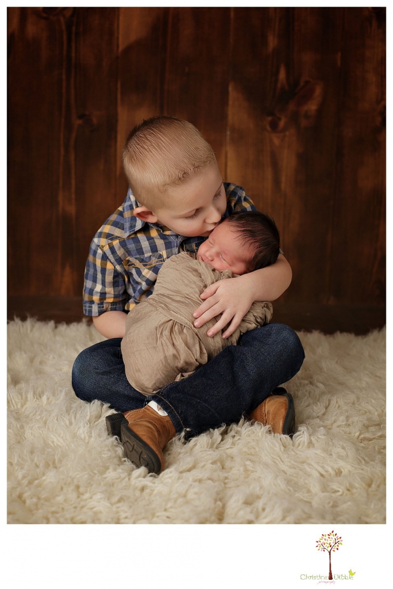 Sonora Newborn Photographer Christine Dibble Photography takes newborn portraits with a hunting camoflage theme including trophy antlers, a vintage wooden shot box and furs.