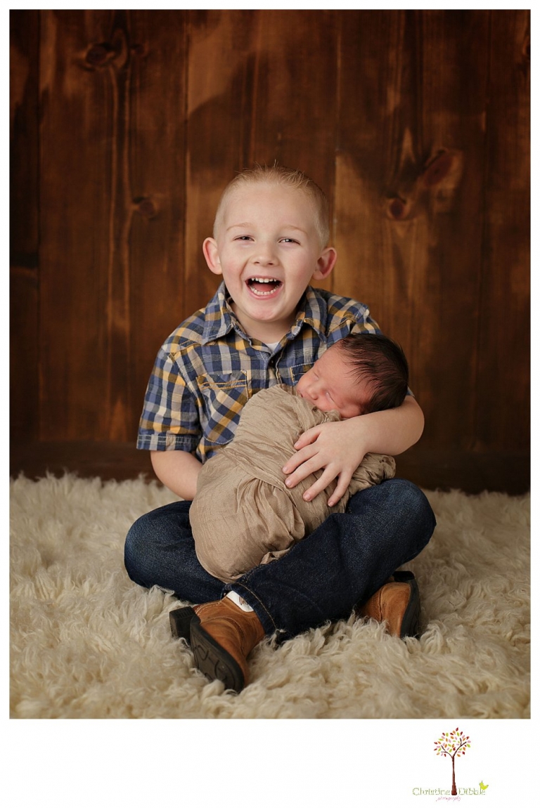 Sonora Newborn Photographer Christine Dibble Photography takes newborn portraits with a hunting camoflage theme including trophy antlers, a vintage wooden shot box and furs.