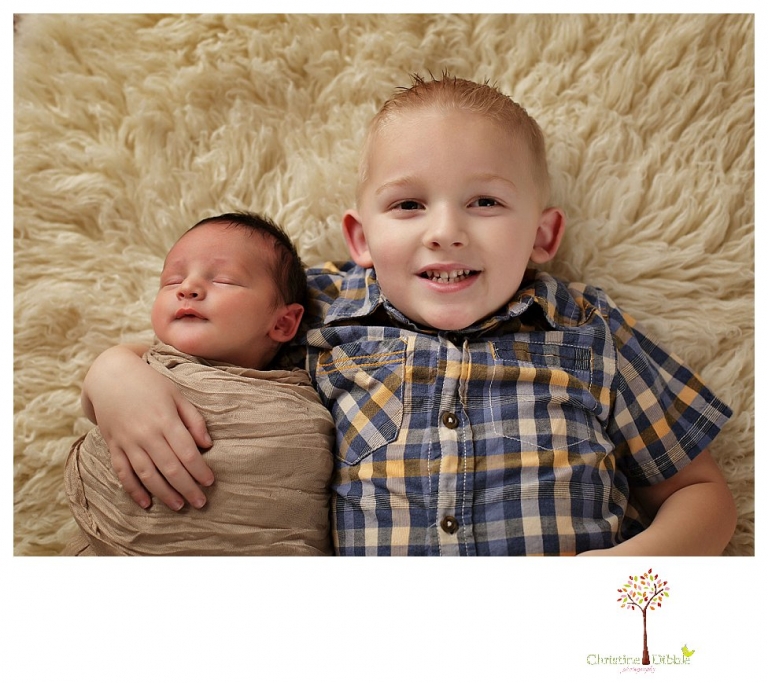 Sonora Newborn Photographer Christine Dibble Photography takes newborn portraits with a hunting camoflage theme including trophy antlers, a vintage wooden shot box and furs.