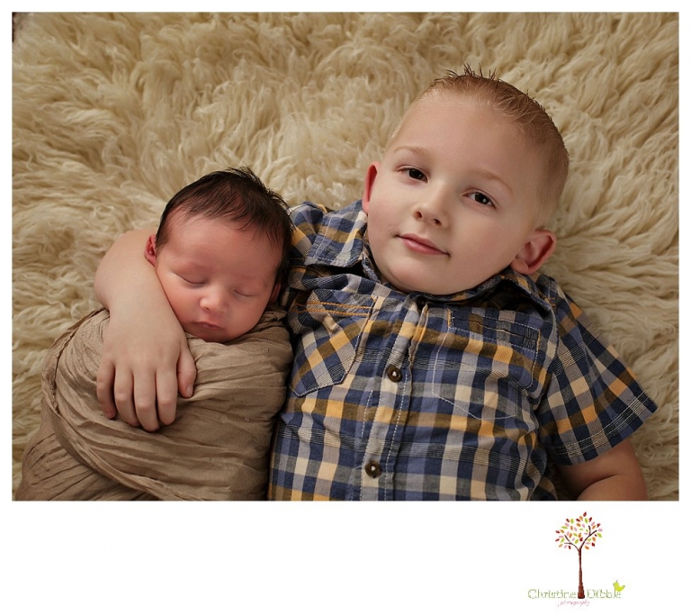 Sonora Newborn Photographer Christine Dibble Photography takes newborn portraits with a hunting camoflage theme including trophy antlers, a vintage wooden shot box and furs.