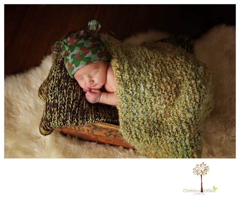 Sonora Newborn Photographer Christine Dibble Photography takes newborn portraits with a hunting camoflage theme including trophy antlers, a vintage wooden shot box and furs.