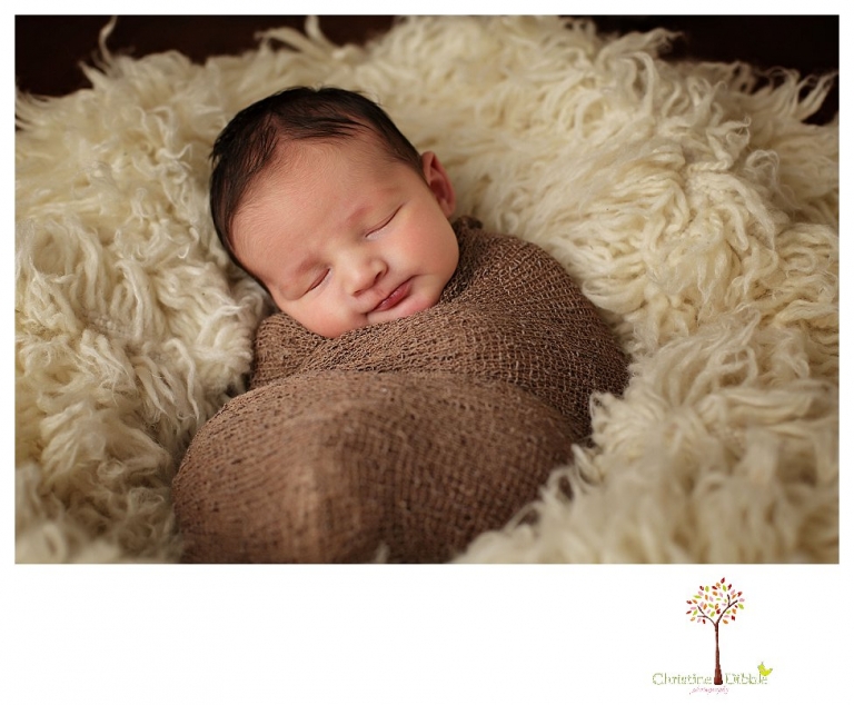 Sonora Newborn Photographer Christine Dibble Photography takes newborn portraits with a hunting camoflage theme including trophy antlers, a vintage wooden shot box and furs.