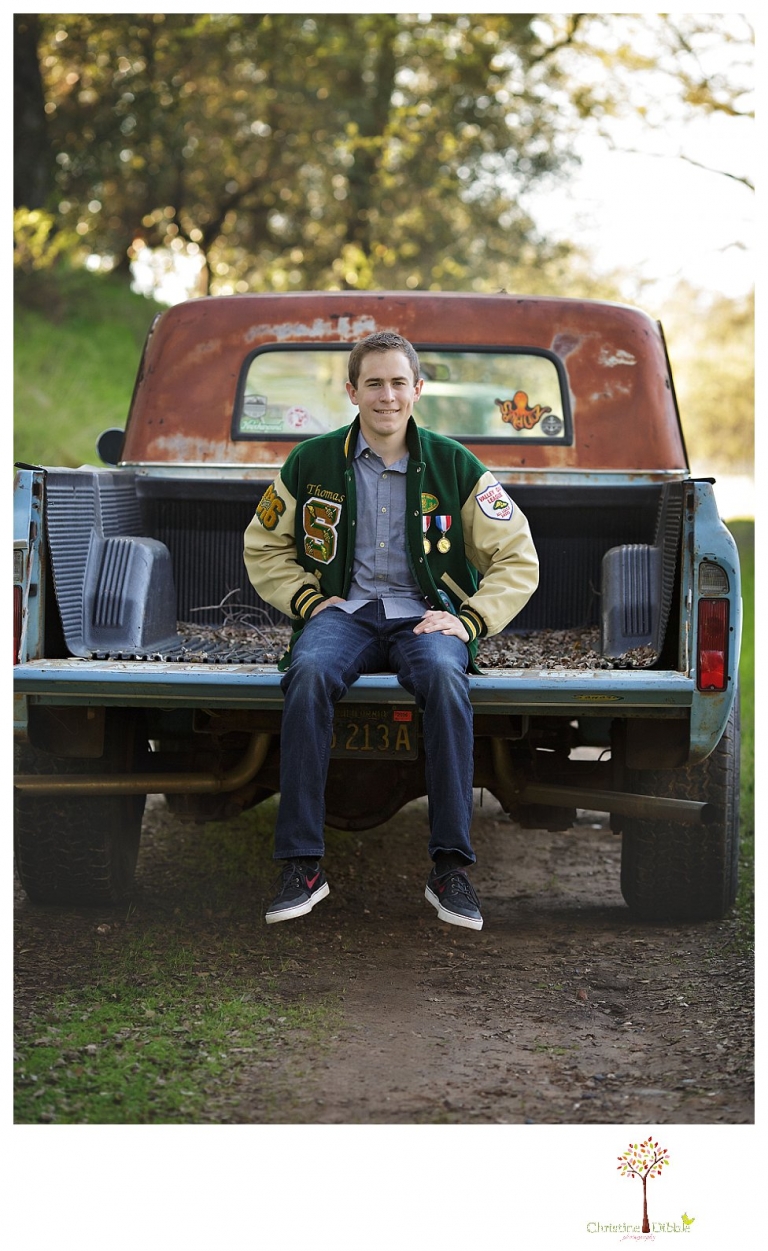 Sonora High senior portrait photographer Christine Dibble Photography takes outdoor spring senior portraits of a track star in his yard with his letterman jacket and old Chevy truck.