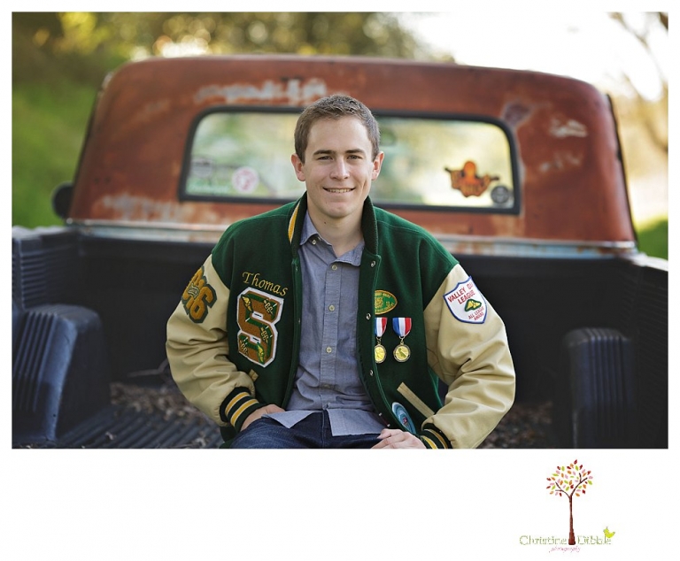 Sonora High senior portrait photographer Christine Dibble Photography takes outdoor spring senior portraits of a track star in his yard with his letterman jacket and old Chevy truck.