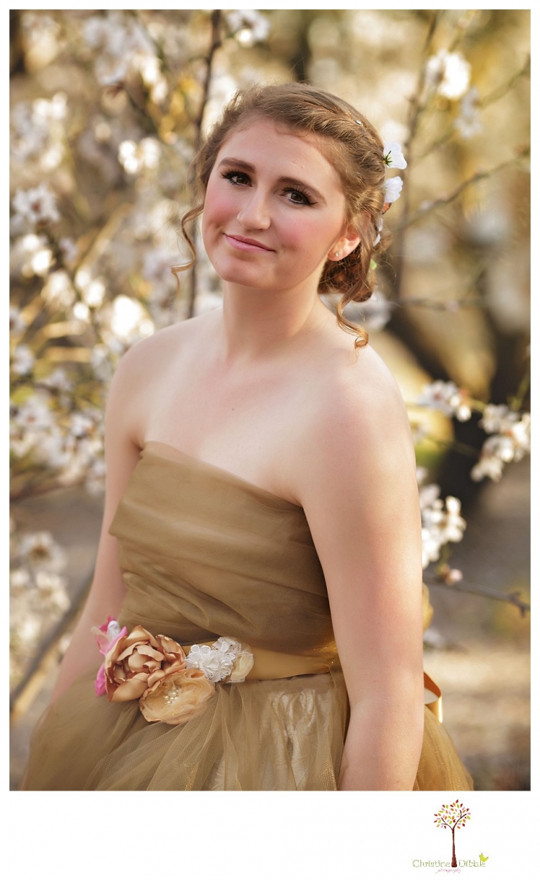 Sonora Summerville Senior Portrait photographer Christine Dibble Photography takes portraits of a senior girl in a full tulle dress among the blossoming trees at Bloomingcamp Ranch in Oakdale.