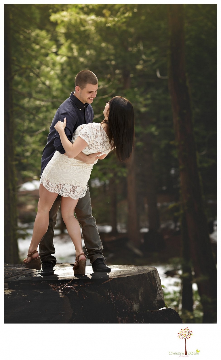 Sonora engagement and wedding photographer Christine Dibble Photography takes engagement photos of a couple in the woods at Pinecrest as they dance on a stump and walk through the trails. 