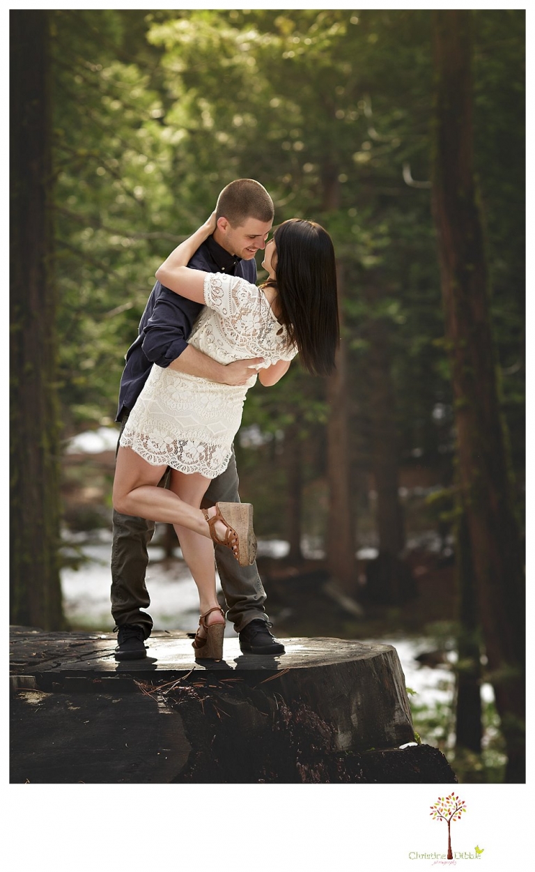 Sonora engagement and wedding photographer Christine Dibble Photography takes engagement photos of a couple in the woods at Pinecrest as they dance on a stump and walk through the trails. 