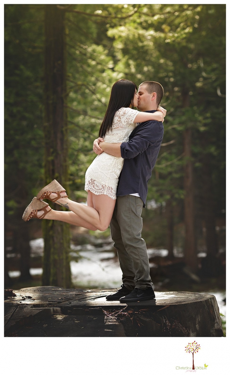 Sonora engagement and wedding photographer Christine Dibble Photography takes engagement photos of a couple in the woods at Pinecrest as they dance on a stump and walk through the trails. 