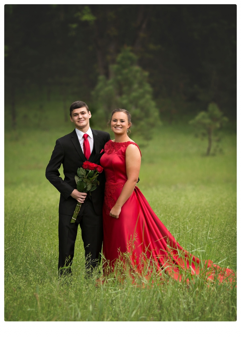Sonora senior portrait photographer Christine Dibble Photography takes portraits of couples before the Summerville High School prom in a field wet from rain with a blue velvet chair.