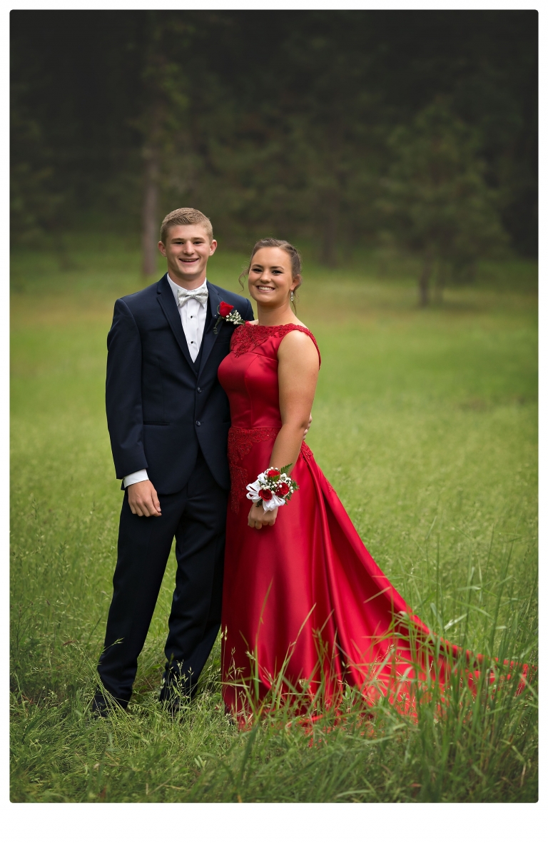 Sonora senior portrait photographer Christine Dibble Photography takes portraits of couples before the Summerville High School prom in a field wet from rain with a blue velvet chair.