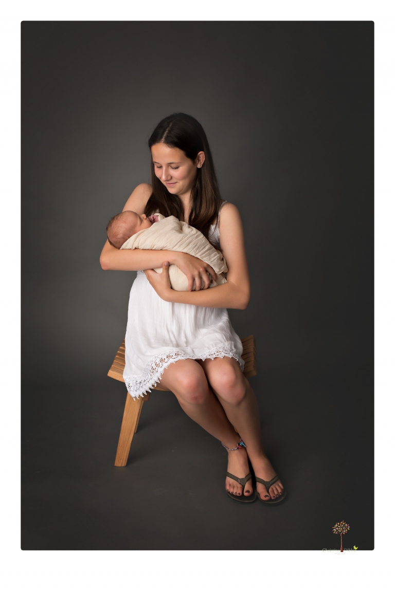 Best Sonora Newborn Photographer Christine Dibble Photography takes studio portraits of a baby sister with her parents and older sister and then posed newborn photos of baby alone.
