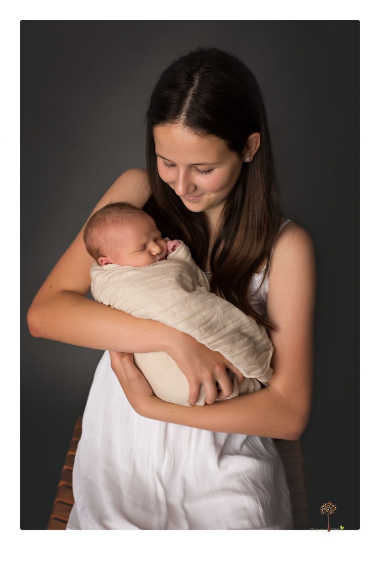 Best Sonora Newborn Photographer Christine Dibble Photography takes studio portraits of a baby sister with her parents and older sister and then posed newborn photos of baby alone.