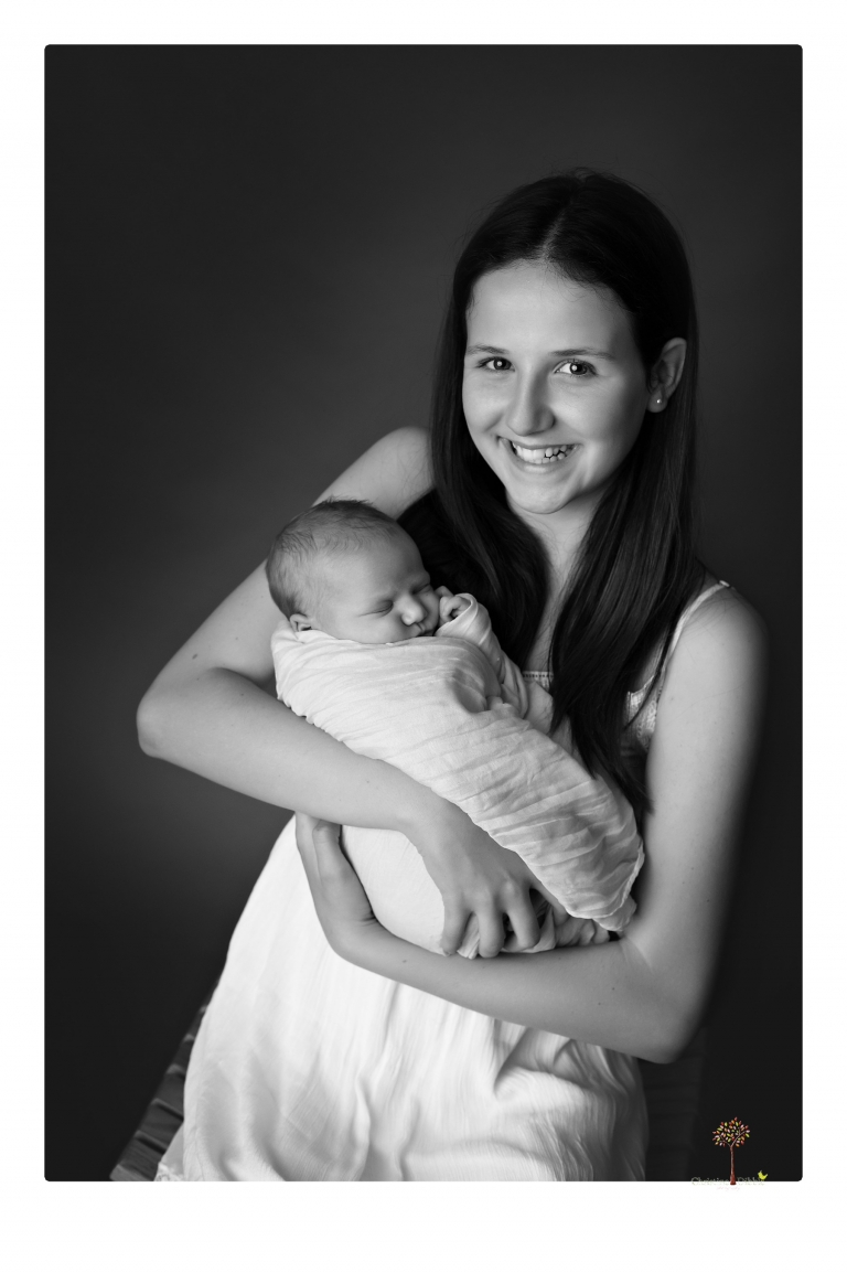 Best Sonora Newborn Photographer Christine Dibble Photography takes studio portraits of a baby sister with her parents and older sister and then posed newborn photos of baby alone.