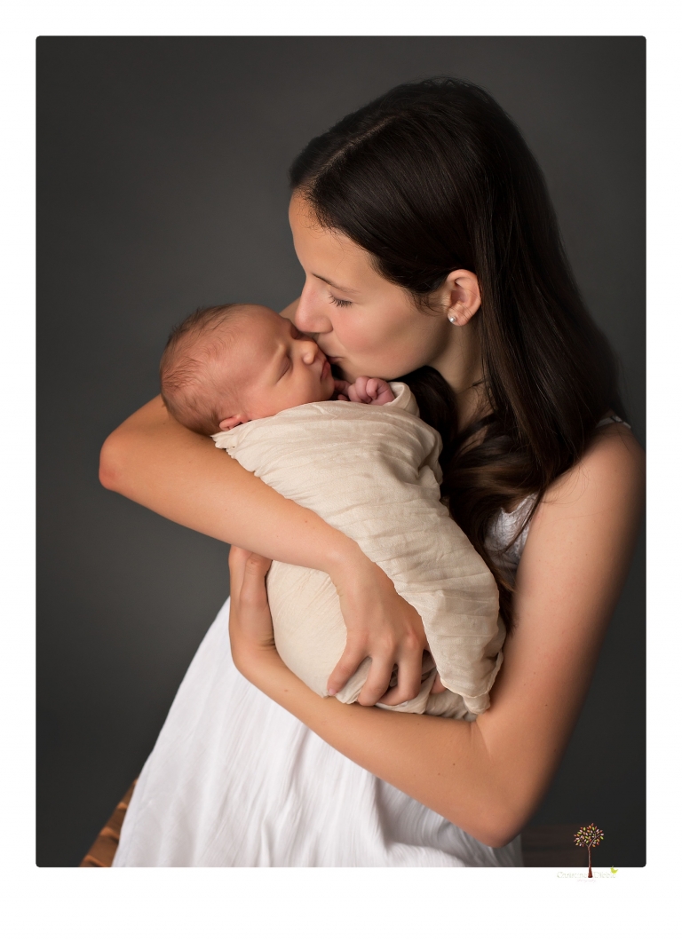 Best Sonora Newborn Photographer Christine Dibble Photography takes studio portraits of a baby sister with her parents and older sister and then posed newborn photos of baby alone.