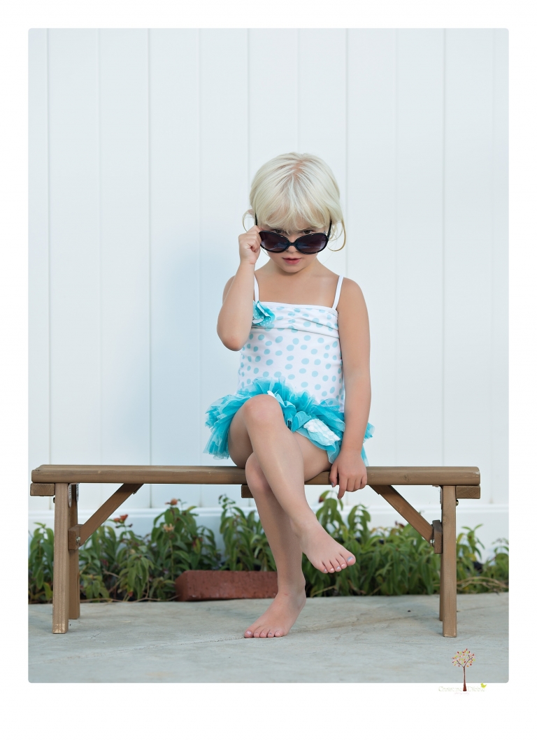 Sonora Child Photographer Christine Dibble Photography takes mermaid birthday photos of a five year old girl in her finfun mermaid tail and a ruffled swimsuit and retro shades.