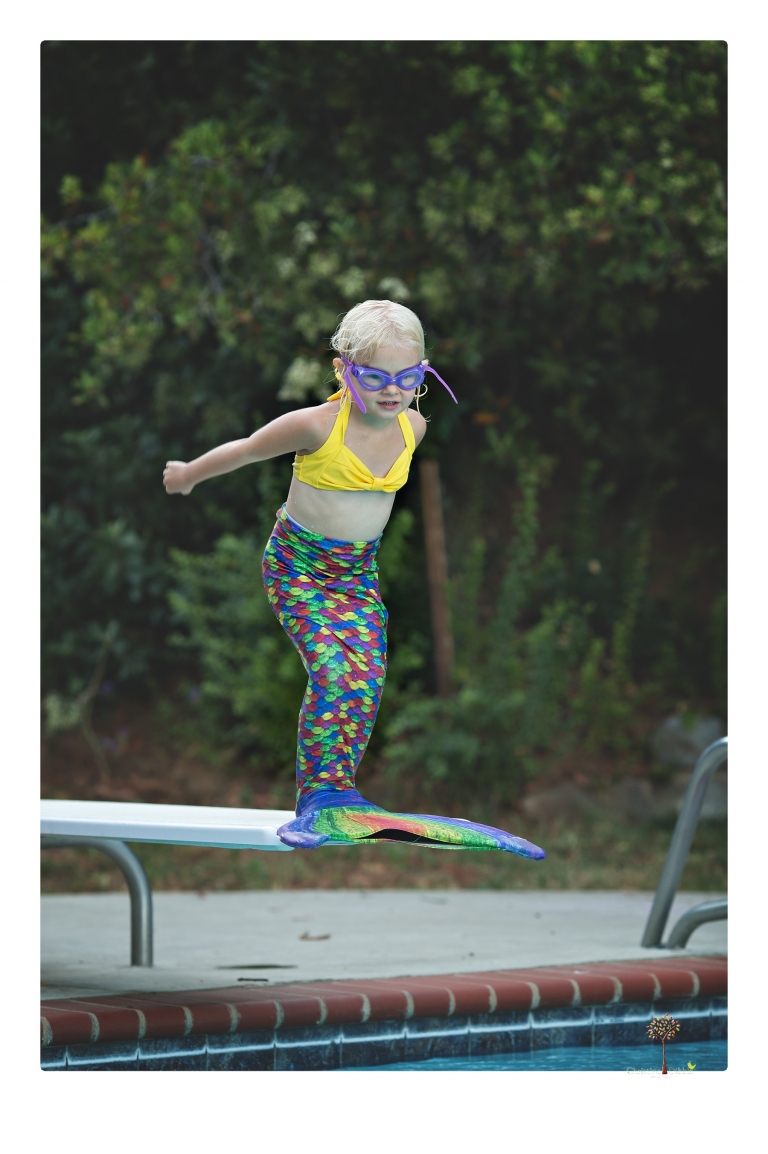 Sonora Child Photographer Christine Dibble Photography takes mermaid birthday photos of a five year old girl in her finfun mermaid tail and a ruffled swimsuit and retro shades.