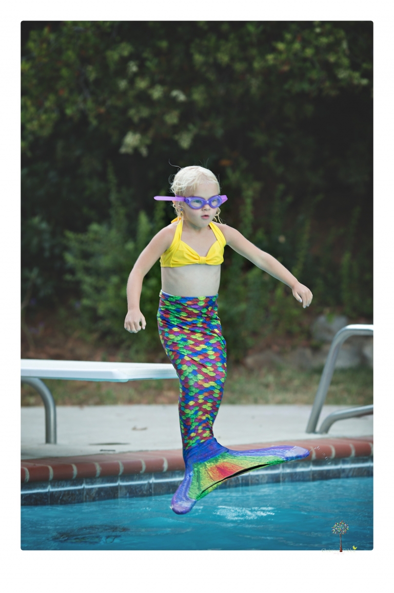 Sonora Child Photographer Christine Dibble Photography takes mermaid birthday photos of a five year old girl in her finfun mermaid tail and a ruffled swimsuit and retro shades.