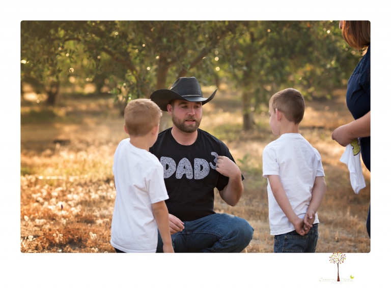 Sonora family photographer Christine Dibble Photography photographs a pregnancy announcement at Hurst Ranch as a wife tells her husband she is pregnant with baby number three during a family portrait session.
