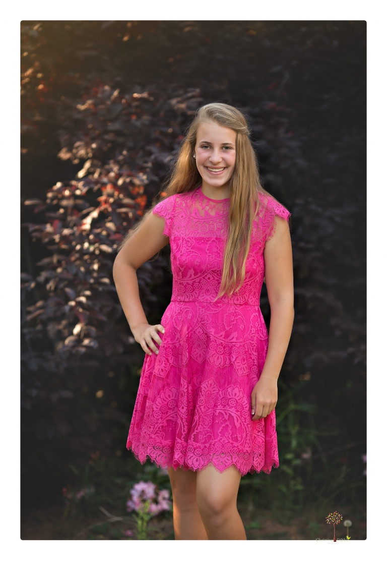 Sonora graduation photographer Christine Dibble Photography takes eighth grade graduation portraits of a girl in a pink lace dress, jeans and cowboy boots with her family, dogs, and steer, Big Mac in her family's yard.