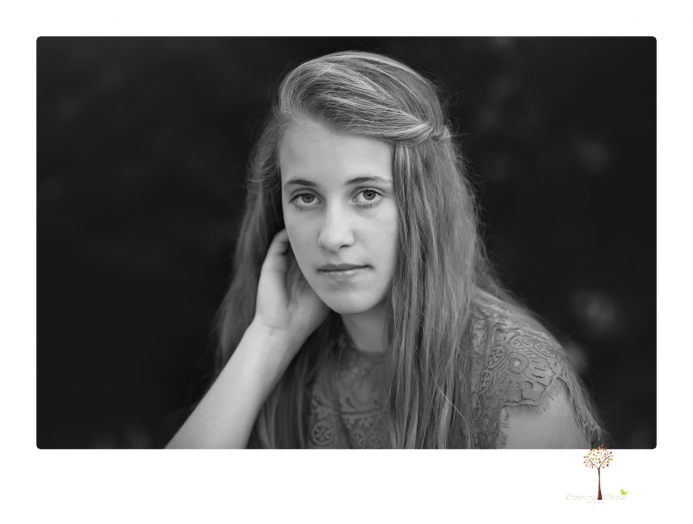 Sonora graduation photographer Christine Dibble Photography takes eighth grade graduation portraits of a girl in a pink lace dress, jeans and cowboy boots with her family, dogs, and steer, Big Mac in her family's yard.