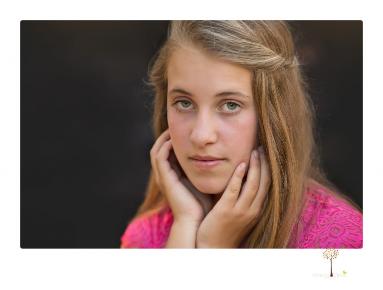 Sonora graduation photographer Christine Dibble Photography takes eighth grade graduation portraits of a girl in a pink lace dress, jeans and cowboy boots with her family, dogs, and steer, Big Mac in her family's yard.