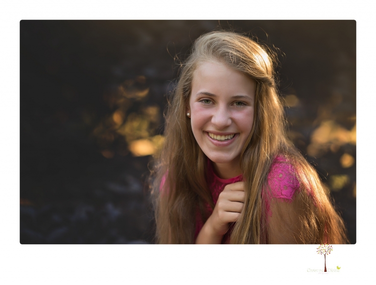 Sonora graduation photographer Christine Dibble Photography takes eighth grade graduation portraits of a girl in a pink lace dress, jeans and cowboy boots with her family, dogs, and steer, Big Mac in her family's yard.