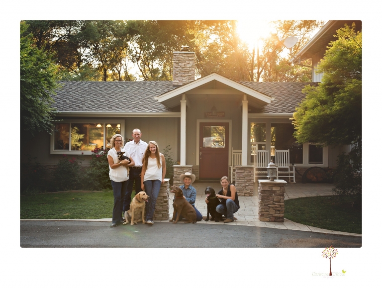 Sonora graduation photographer Christine Dibble Photography takes eighth grade graduation portraits of a girl in a pink lace dress, jeans and cowboy boots with her family, dogs, and steer, Big Mac in her family's yard.
