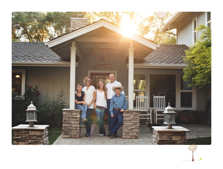 Sonora graduation photographer Christine Dibble Photography takes eighth grade graduation portraits of a girl in a pink lace dress, jeans and cowboy boots with her family, dogs, and steer, Big Mac in her family's yard.