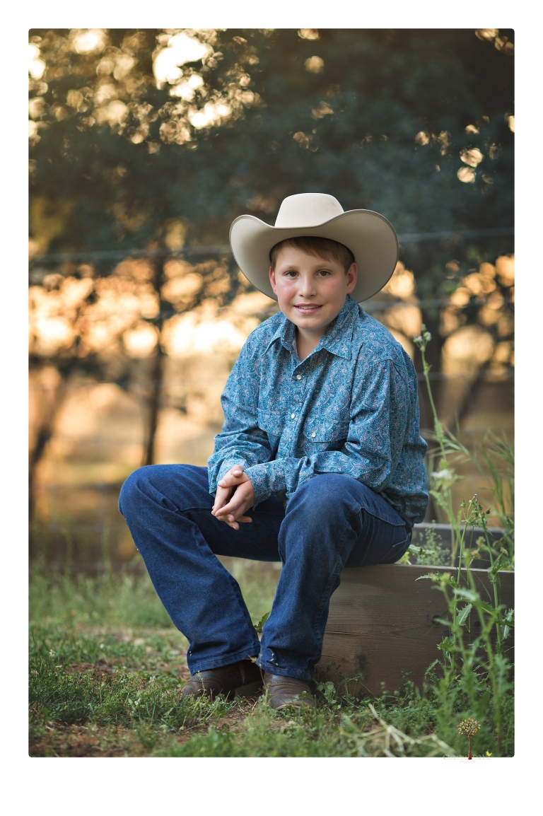 Sonora graduation photographer Christine Dibble Photography takes eighth grade graduation portraits of a girl in a pink lace dress, jeans and cowboy boots with her family, dogs, and steer, Big Mac in her family's yard.