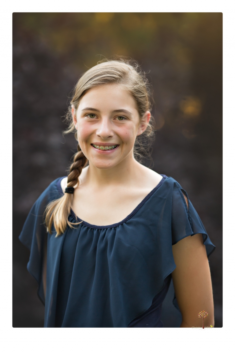 Sonora graduation photographer Christine Dibble Photography takes eighth grade graduation portraits of a girl in a pink lace dress, jeans and cowboy boots with her family, dogs, and steer, Big Mac in her family's yard.