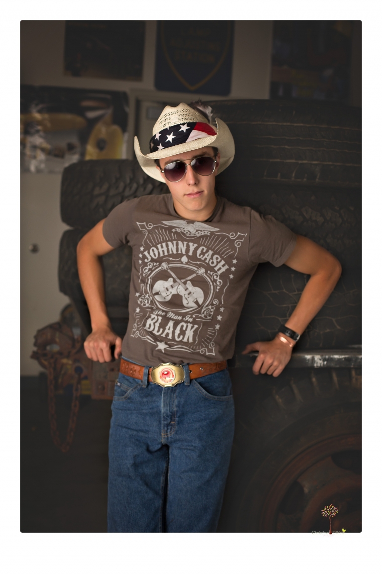 Summerville Senior Portraits taken by Christine Dibble Photography of Sonora in the auto shop with a senior boy's 1959 Jeep Willys pick-up truck and his letterman jacket.