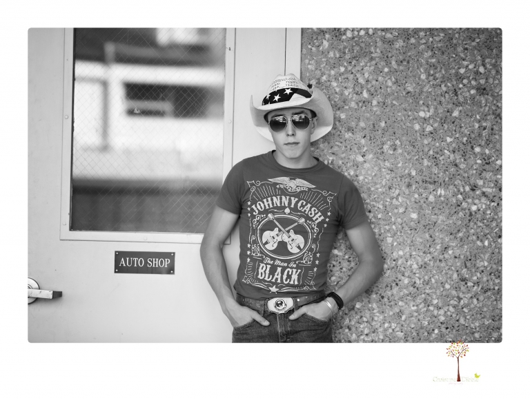 Summerville Senior Portraits taken by Christine Dibble Photography of Sonora in the auto shop with a senior boy's 1959 Jeep Willys pick-up truck and his letterman jacket.