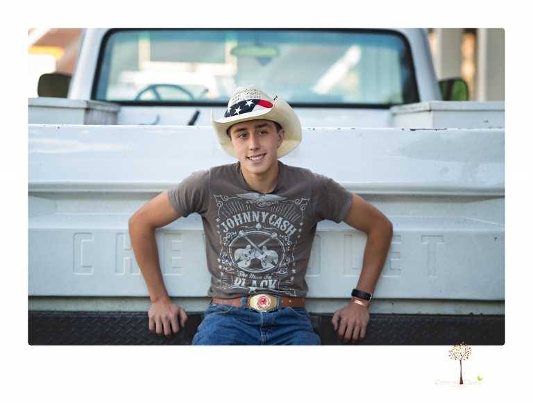Summerville Senior Portraits taken by Christine Dibble Photography of Sonora in the auto shop with a senior boy's 1959 Jeep Willys pick-up truck and his letterman jacket.