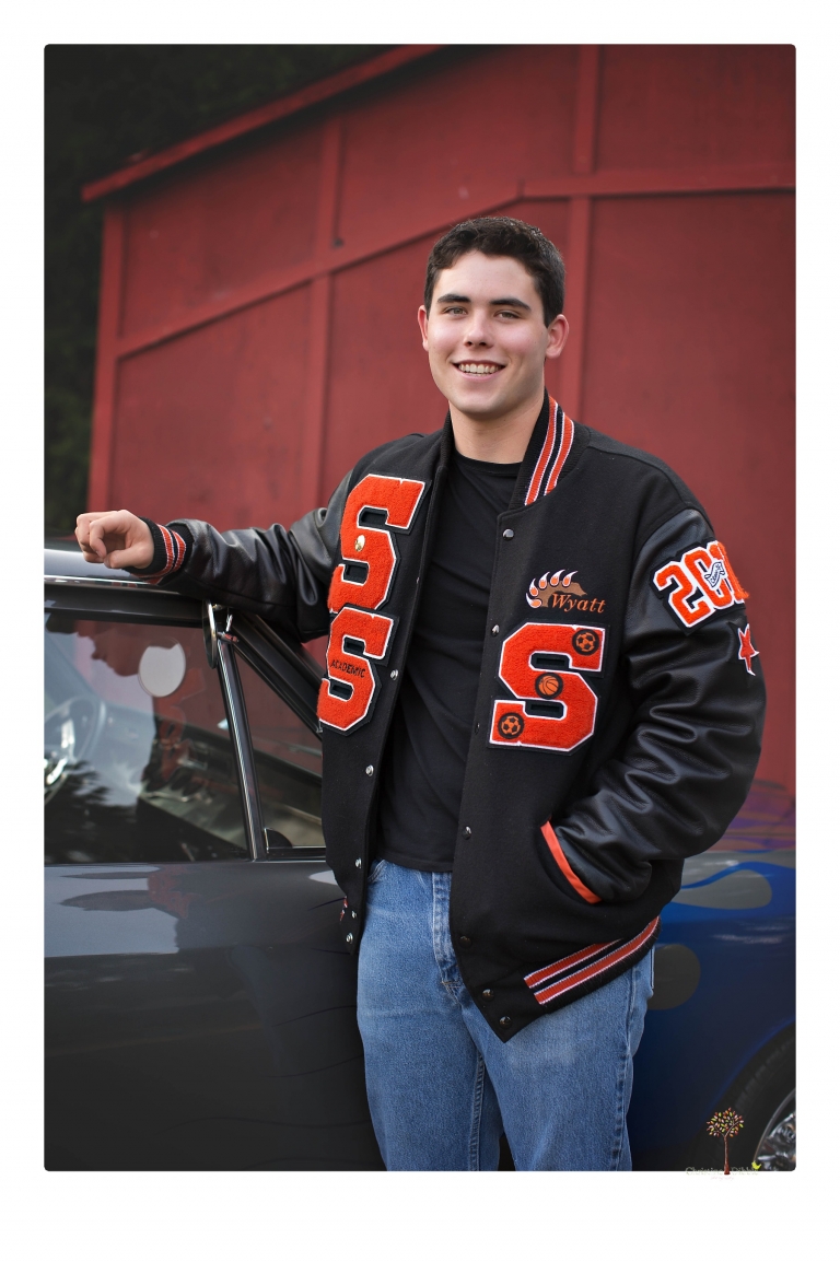 Summerville High senior portrait photographer Christine Dibble of Sonora takes senior portraits of a boy at Twain Harte Tree Farm with his trumpet, letterman jacket, and his dad's classic 1966 Chevelle.