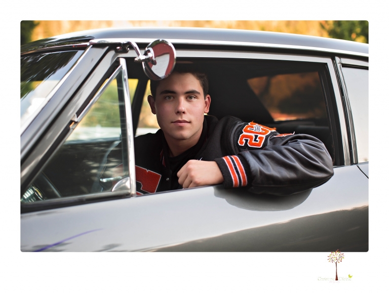 Summerville High senior portrait photographer Christine Dibble of Sonora takes senior portraits of a boy at Twain Harte Tree Farm with his trumpet, letterman jacket, and his dad's classic 1966 Chevelle.