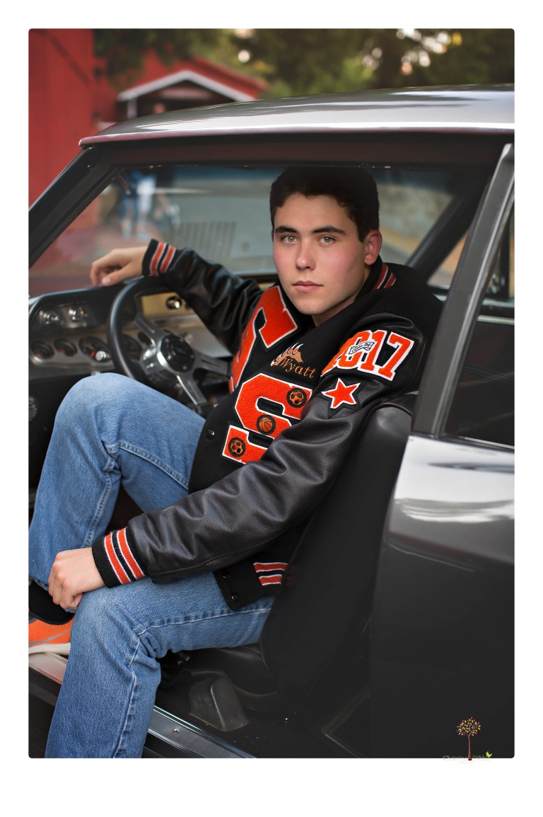 Summerville High senior portrait photographer Christine Dibble of Sonora takes senior portraits of a boy at Twain Harte Tree Farm with his trumpet, letterman jacket, and his dad's classic 1966 Chevelle.