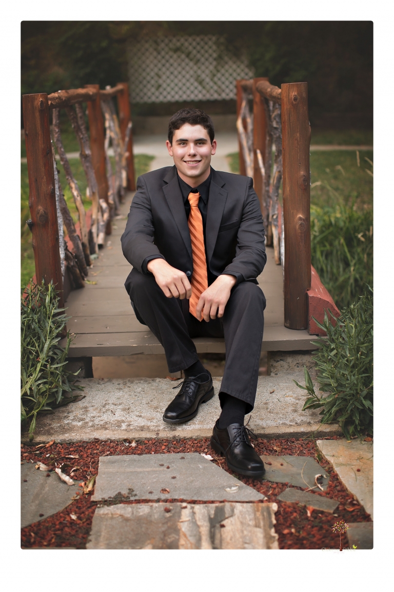 Summerville High senior portrait photographer Christine Dibble of Sonora takes senior portraits of a boy at Twain Harte Tree Farm with his trumpet, letterman jacket, and his dad's classic 1966 Chevelle.