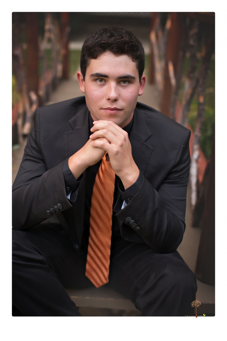 Summerville High senior portrait photographer Christine Dibble of Sonora takes senior portraits of a boy at Twain Harte Tree Farm with his trumpet, letterman jacket, and his dad's classic 1966 Chevelle.