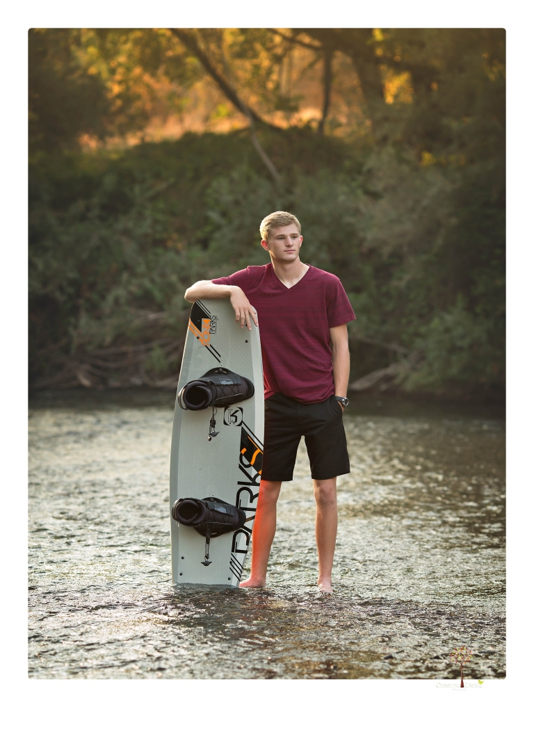 Summerville High senior portrait photographer Christine Dibble Photography of Sonora takes senior portraits of a wrestler at Knights Ferry with his wake board in the river, his jeep and letterman jacket.
