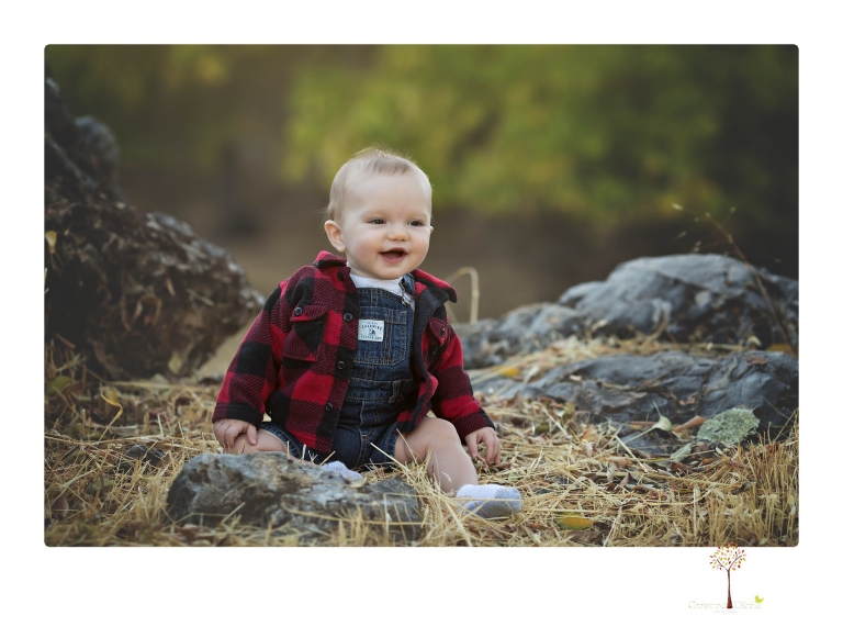Sonora baby photographer Christine Dibble Photography takes photos of an eight month old baby boy in a field in Columbia with a stuffed dog and pumpkins.