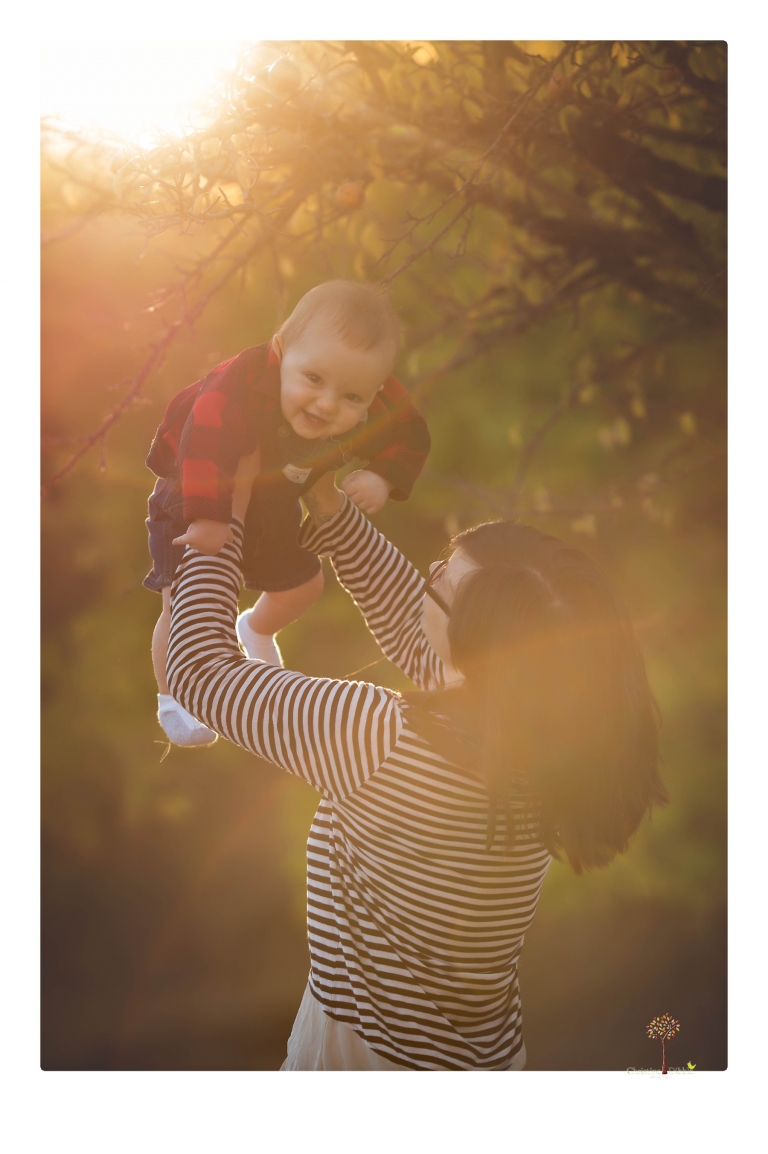 Sonora baby photographer Christine Dibble Photography takes photos of an eight month old baby boy in a field in Columbia with a stuffed dog and pumpkins.