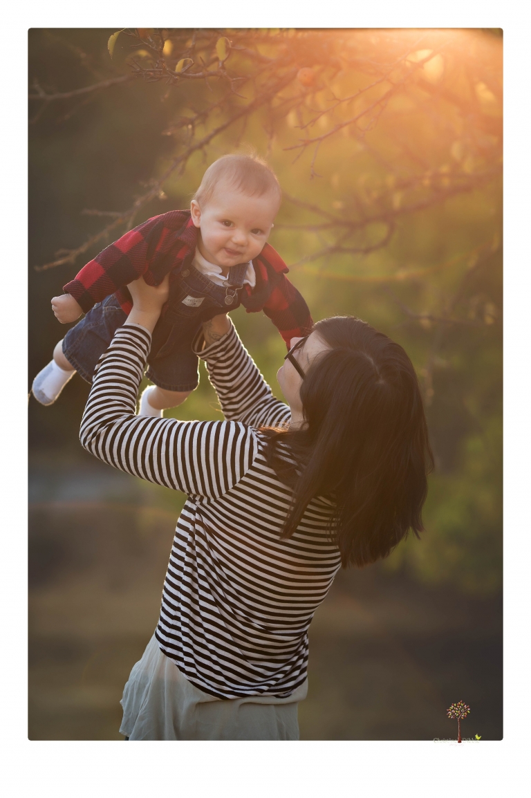 Sonora baby photographer Christine Dibble Photography takes photos of an eight month old baby boy in a field in Columbia with a stuffed dog and pumpkins.