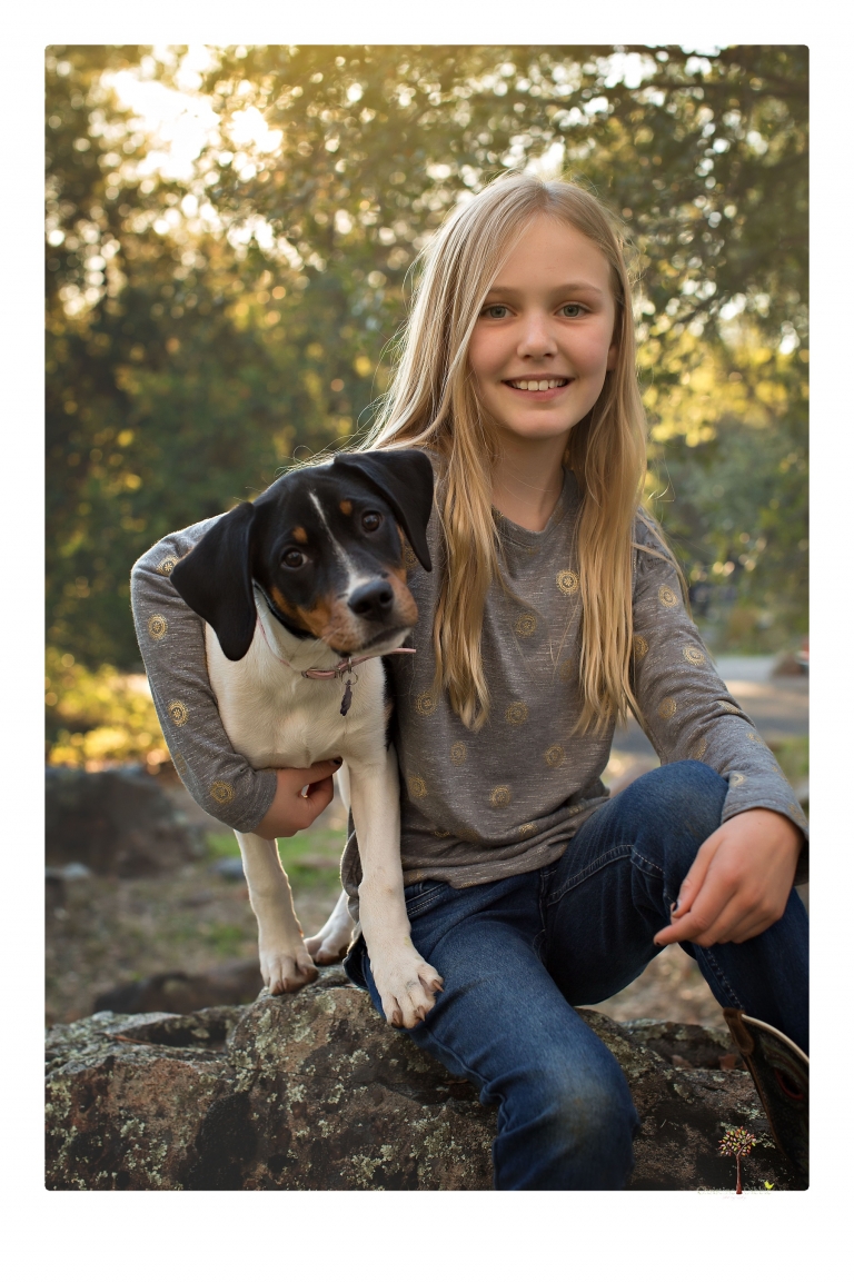 Sonora family photographer Christine Dibble Photography takes family portraits in a private vineyard as a family plays and climbs trees and rocks.