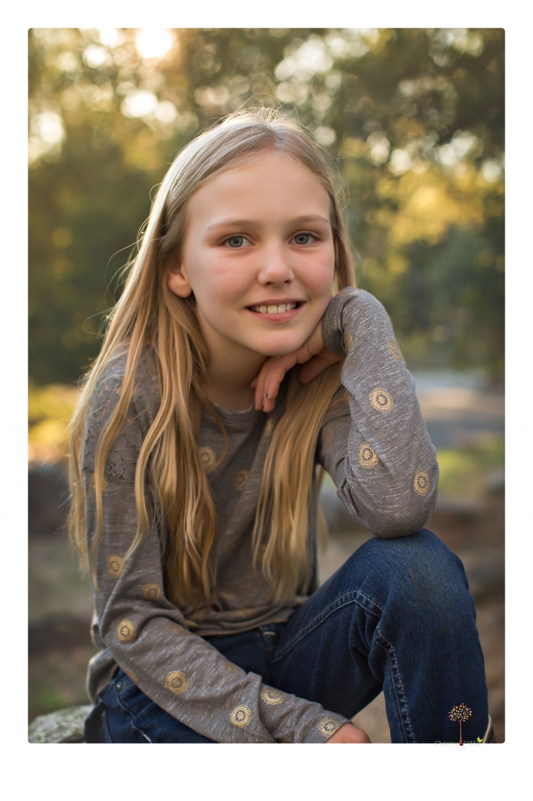 Sonora family photographer Christine Dibble Photography takes family portraits in a private vineyard as a family plays and climbs trees and rocks.