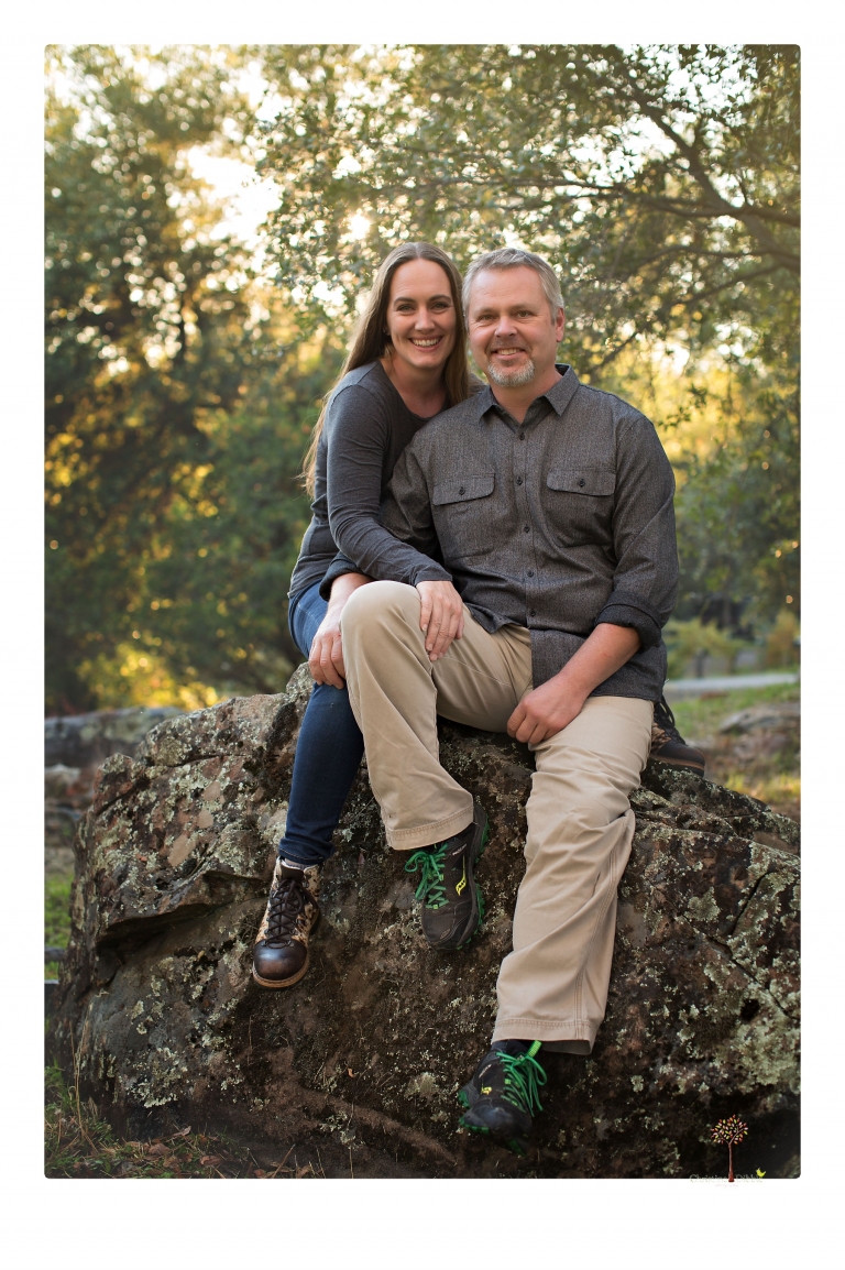 Sonora family photographer Christine Dibble Photography takes family portraits in a private vineyard as a family plays and climbs trees and rocks.
