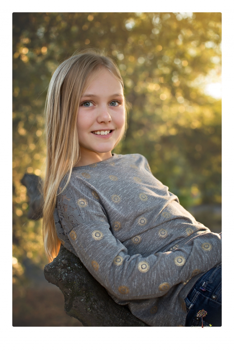 Sonora family photographer Christine Dibble Photography takes family portraits in a private vineyard as a family plays and climbs trees and rocks.